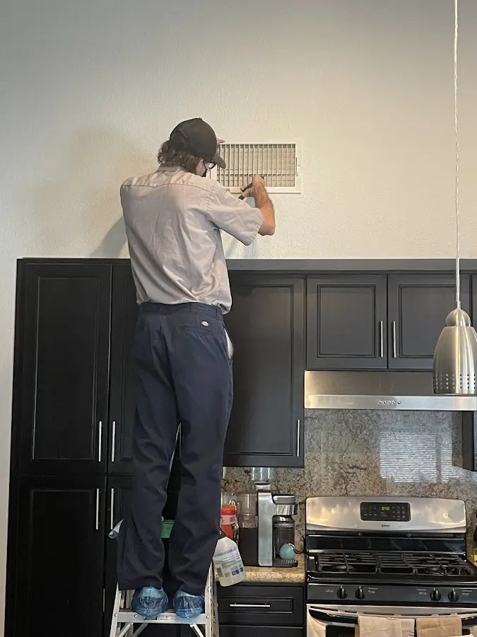 Technician inspecting an air vent during HVAC service in Sheboygan